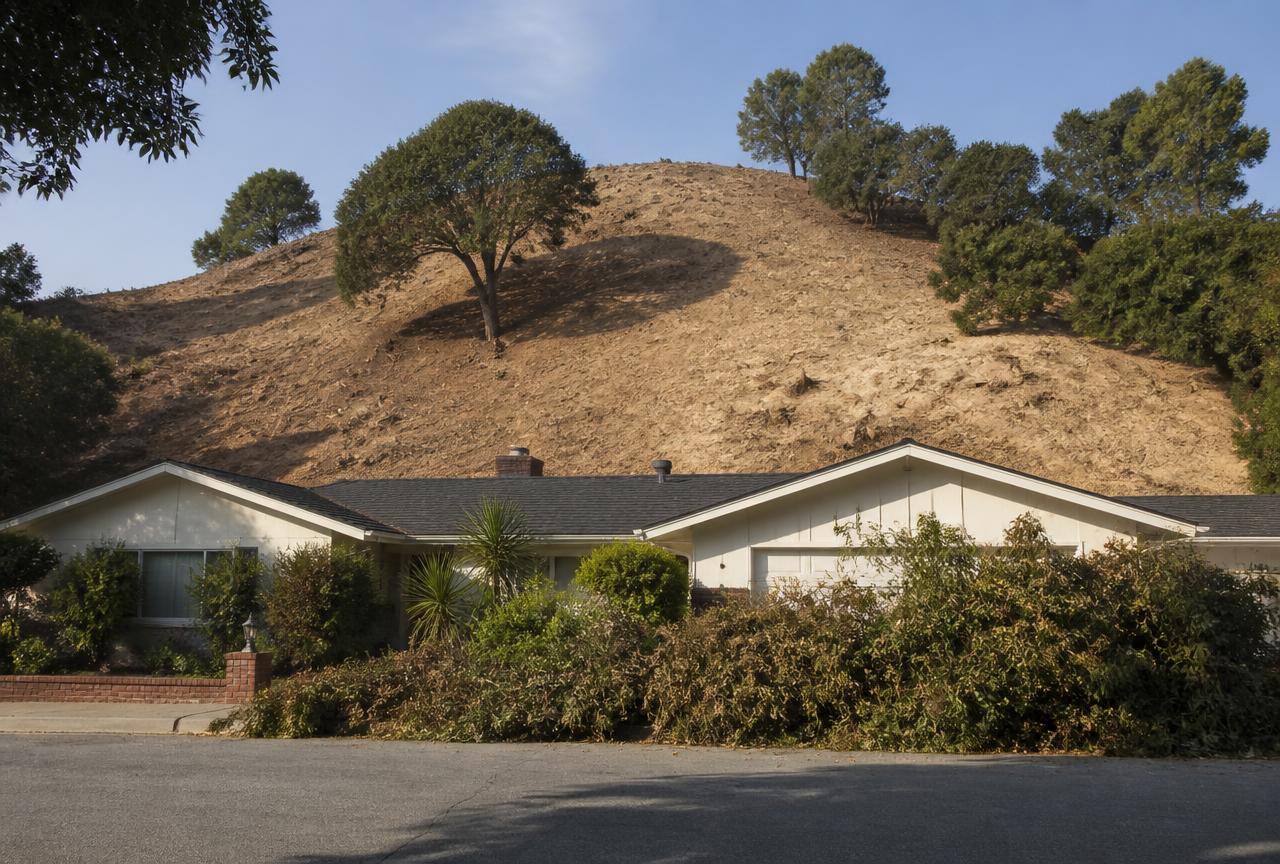Steep hillside behind a California home cleared of brush and poison oak